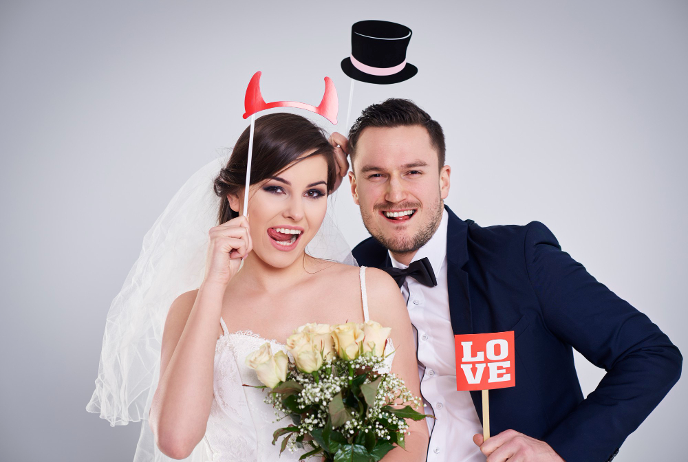 Wedding photo booth New Orleans bride and groom using fun props